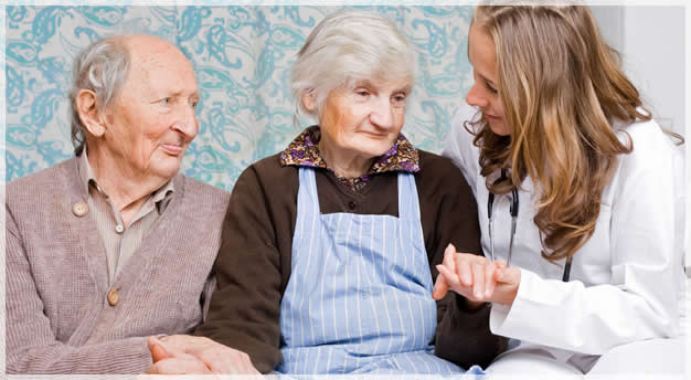 elderly couple with their caregiver