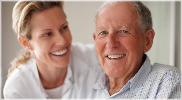 elderly man and caregicer smiling
